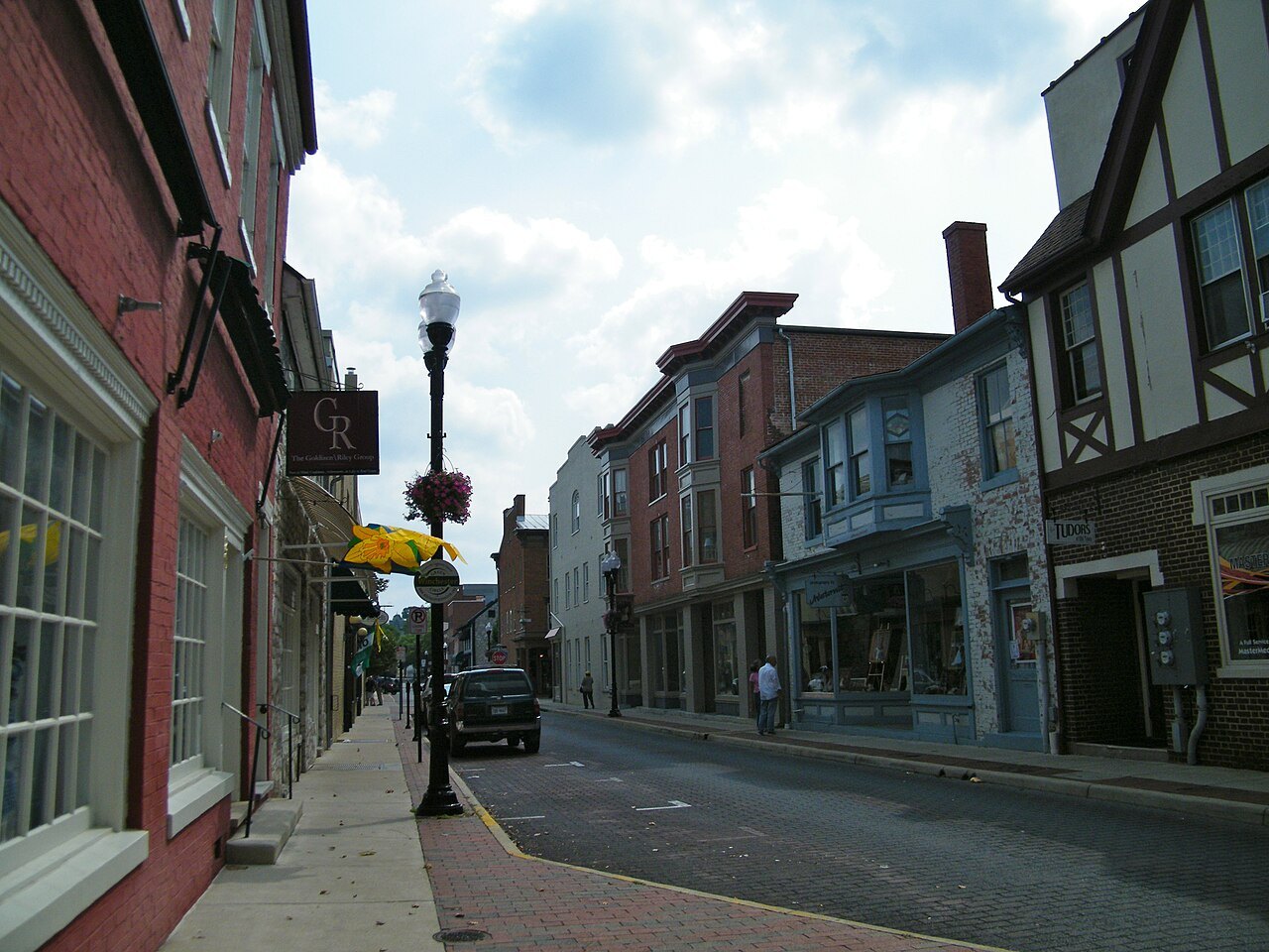 A downtown street in Winchester, Virginia, with brick storefronts and hanging flower baskets